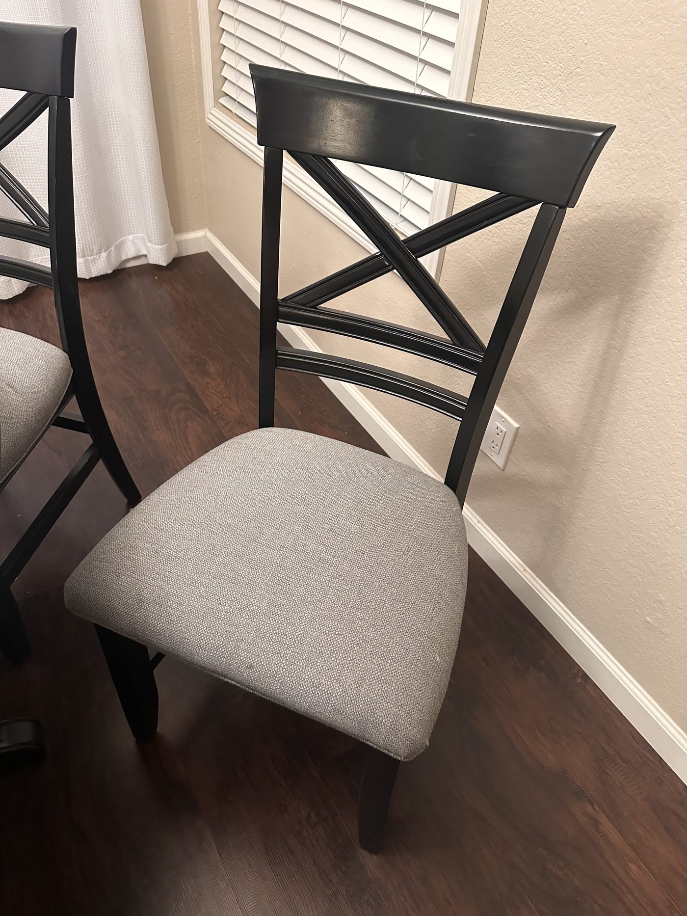 Close-up of a reupholstered dining chair with woven gray seat